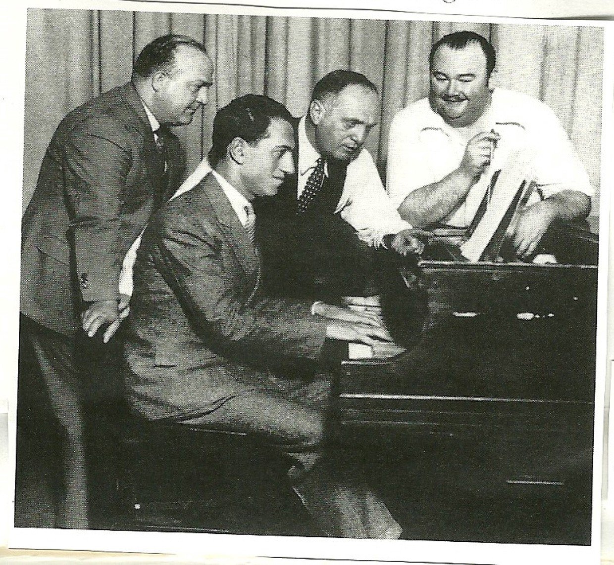 George Gershwin at the piano. Left to right: Ferde Grofé, Samuel “Roxy” Rothafel, and Paul Whiteman